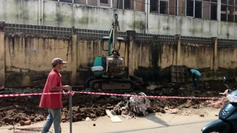 Man operating an excavator on a construction site by the street Stock Footage 146766746