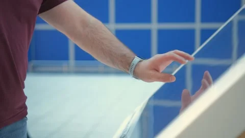 A man is operating a hightech interactive touchscreen display in a modern indoor Stock Footage 276588978