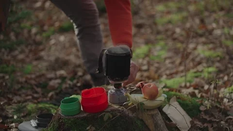 Man operating portable, stabilized cooking system to rapidly boil water while Stock Footage 323470089