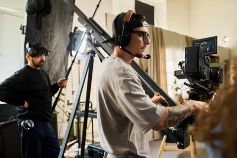 Man Operating Professional Video Camera Crane in Studio Stock Photos