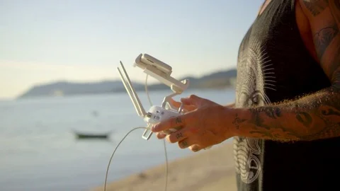 Man operating remote control of drone on beach Stock Footage 74777511