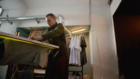 Man Operating Screen Printing Press with Squeegee Stock-Footage 333160181