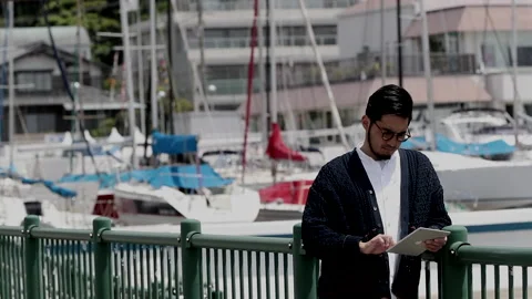 Man operating tablet by the sea Stock Footage 161874002