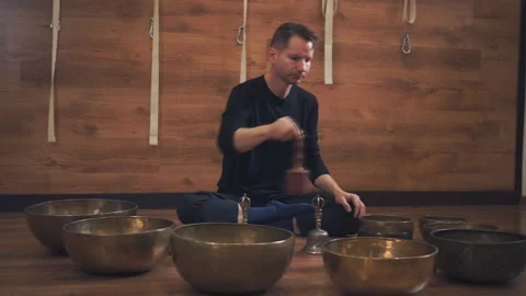 Man operating with Tibetan singing bowls Stock Footage 98463530