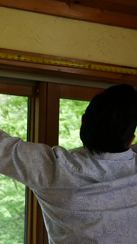 A Man or Contractor Measures a Large Window - Angle 2 - Vertical Vidéo 333706679