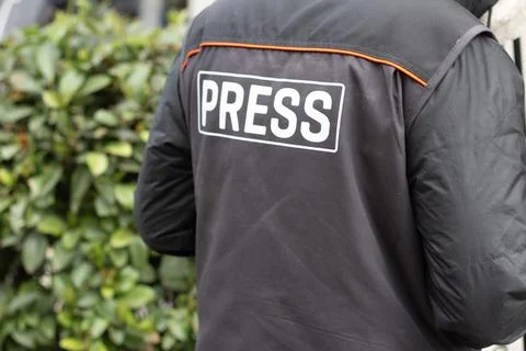 Man or woman in black jacket with inscription Press in outline Stock-Fotos