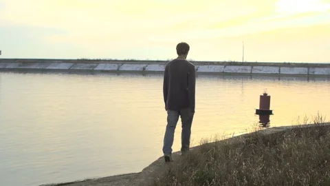 Man with an orange in his hand is on the beach in slow motion. Stock Footage 72593411