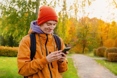 Man In Orange Jacket Using Smartphone Outdoors In Autumn Stock Photos