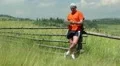 Man in orange t-shirt with Tablet PC stands in the field HD Footage
