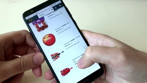 A man orders apples in an online store using a smartphone. The choice of Stock Footage 128046825