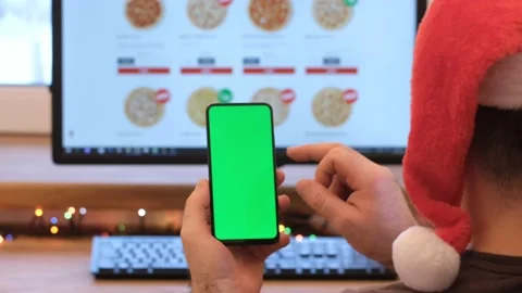 A man orders pizza. Man in office is holding a smartphone with a green screen Stock Footage 172559600