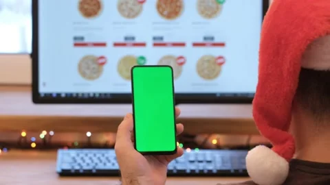 A man orders pizza. Man in office is holding a smartphone with a green screen Stock Footage 180781812