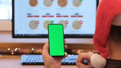 A man orders pizza. Man in office is holding a smartphone with a green screen Stock Footage 185856619