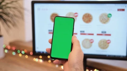 A man orders pizza. Pizza. A man in her office is holding a smartphone with a Stock Footage 169459703