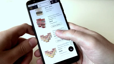 A man orders rice in an online store using a smartphone. The choice of products Stock Footage 128046984