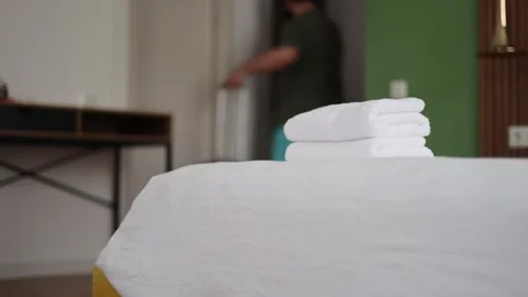 Man out of focus in blue summer shorts leaving hotel room with suitcase 스톡 동영상 314505857