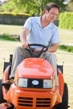 Man outdoors driving lawnmower Stock Photos