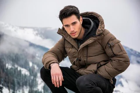Man in outerwear sitting while looking at camera Stock Photos