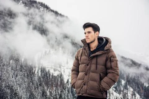 Man in outerwear sitting while looking at camera Stock Photos