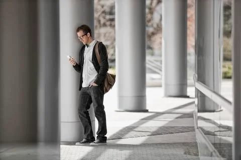 A man outside a building, checking his smart phone. Fotos de archivo