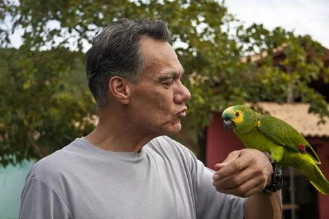 Man outside with his Blue Fronted Amazon Parrot Stock Photos