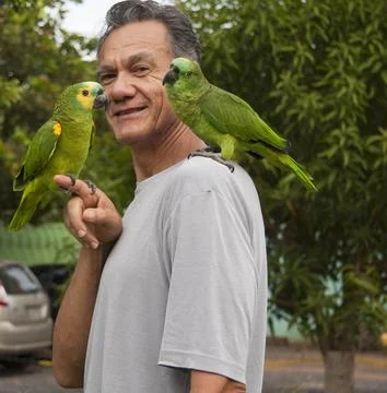 Man outside with his Blue Fronted Amazon Parrot Stock Photos