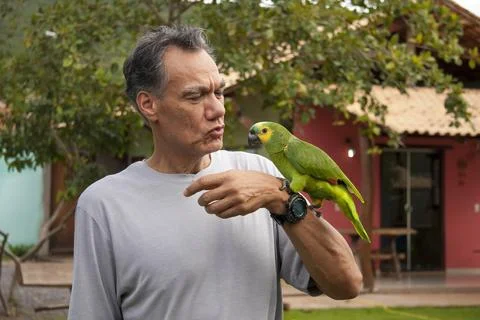 Man outside with his Blue Fronted Amazon Parrot Stock Photos