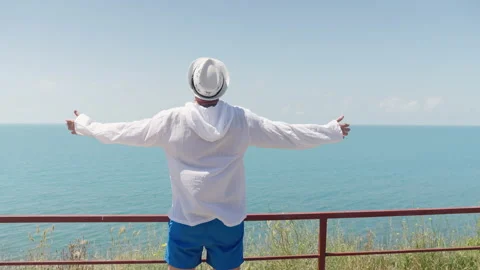 Man with outstretched arms against the background of the blue sea and sky Video stock 201246815