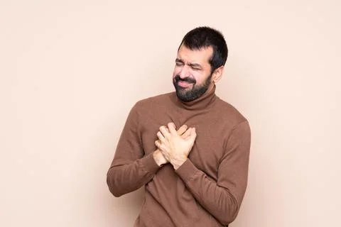 Man over isolated background having a pain in the heart Stock Photos