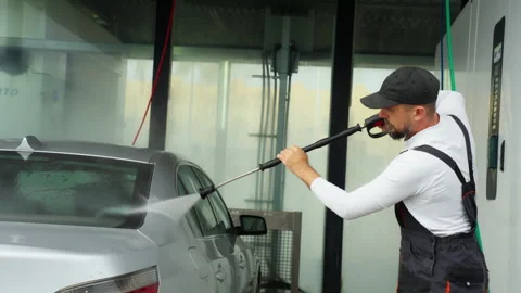 Man in overalls carefully wash silver car at self-service car wash, utilizi.. Stock Footage 320890281