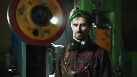 A man in overalls stands in a workshop Video stock 166955519