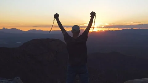 A man overjoyed to be free from chains at sunset Stock Footage 337726717