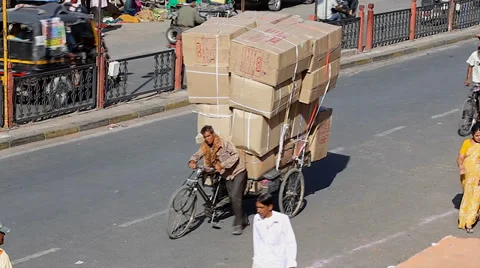 Man overloads a three wheeled bicycle to deliver rice on busy streets in India. Stock Footage 37516562