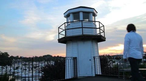 Man overlooking harbor next to light house Stock Footage 28048976