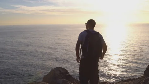 Man overlooking ocean from a cliff, 4k Stock Footage 103438321