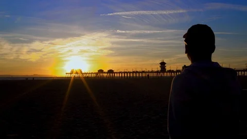 Man overlooking sunset at beach, 4K Stock Footage 101002335