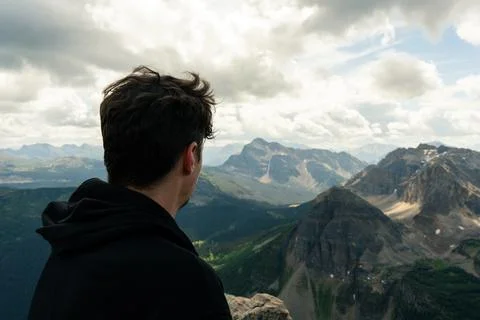 Man Overlooking Vast Mountain Range in Cloudscape Stock Photos