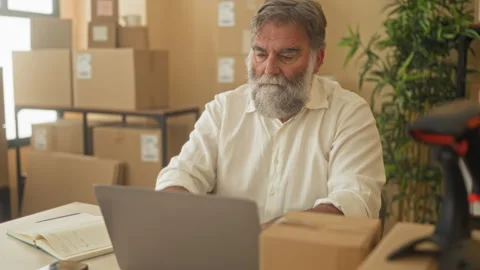 Man with packages stretches arms behind head in a building office near lapt.. Stock Footage 339201110