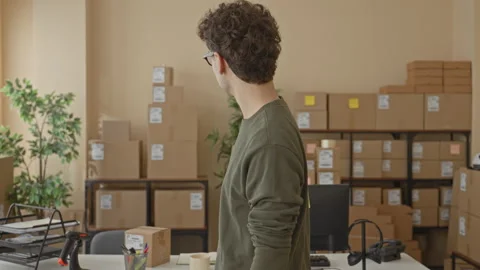 Man with packages turning head and smiling while holding a parcel and stand.. Stock Footage 337435984