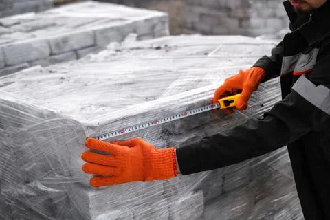 A man packing bricks into pallets at a construction site Foto stock
