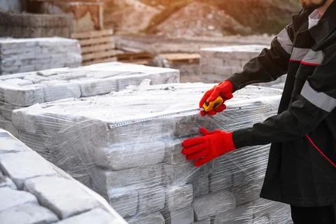 A man packing bricks into pallets at a construction site Stock Photos
