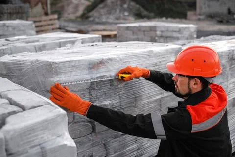 A man packing bricks into pallets at a construction site Fotos de archivo