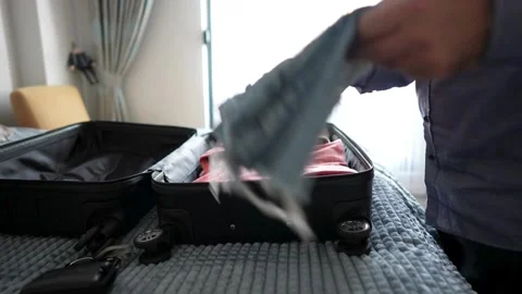 Man packing her clothes in a bag Preparing suitcase holiday or vacation Video stock 336236801