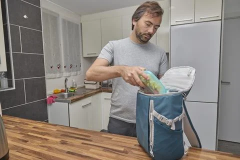 Man Packing Lunch into Backpack Stock Photos