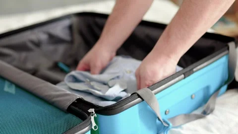 Man packing a suitcase for trip closeup. Travel concept slow motion. Stock Footage 301558698
