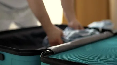 Man packing a suitcase for trip closeup. Travel concept slow motion. Stock Footage 301558722