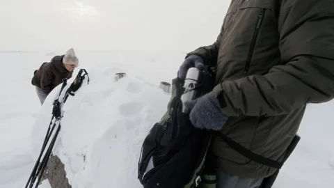 Man Packing Thermos into Backpack during Winter Hiking Adventure Stock Footage 341311932