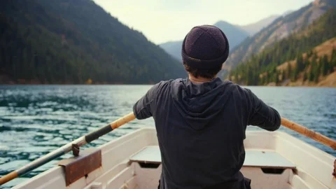Man padding on boat or canoe in lake , pine woods mountains in active vacations Stock Footage 104046477