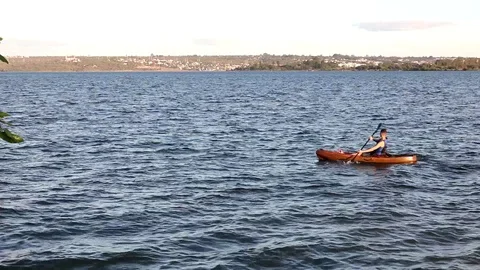 Man Padding a Canoe on Paranoa Lake Stock Footage 113056957