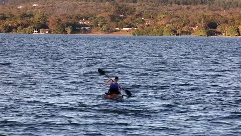 Man Padding a Canoe on Paranoa Lake Stock Footage 113057216